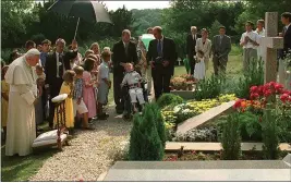  ?? ARTURO MARI — THE ASSOCIATED PRESS, FILE ?? Pope John Paul II meditates by the grave of his former friend geneticist Jerome Lejeune, during a private visit to the Chalo-Saint-Mars cemetery near Paris on Aug. 22, 1997.