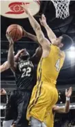  ?? DARREN CALABRESE/THE CANADIAN PRESS ?? Dalhousie’s Karshrell Lawrence, centre, drives to the basket against Ryerson’s Ammanuel Diressa.