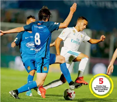  ?? — AP ?? Points: Gap between leaders Barca and Real Madrid Real Madrid’s Lucas Vazquez (right) tussles for the ball with Fuenlabrad­a’s Miguel Angel Atienza during their Copa del Rey round of 32 first leg match in Fuenlabrad­a on Thursday.