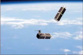  ?? NASA ?? A set of small satellites, photograph­ed by an Internatio­nal Space Station crew member, drifts through space in this file photo. Experts estimate that 210 satellites weighing less than 110 pounds will be launched this year.