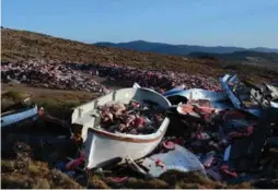  ??  ?? The dump above the village of Molyvos with thousands of life-jackets next to boats collected from the rocky shores, evidence of last year’s refugee crisis.