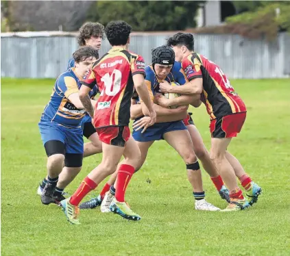  ?? PHOTO: LINDA ROBERTSON ?? No way through . . . Taieri player Josh Munro is tackled by Dunstan defenders Raf Love (left) and Finn O’Brien during their Otago Schools Rugby Championsh­ip game in Mosgiel on Saturday. Jacob de Clifford (far left) is in support for Taieri.