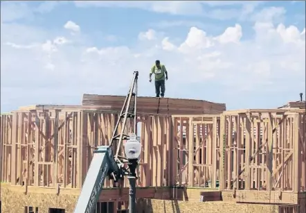  ?? A FRAMER
Mark Boster Los Angeles Times ?? works Tuesday on a new house going up at the William Lyon Homes site in the Pavilion Park developmen­t in Irvine.