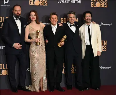  ?? ?? (From left) Greek director Yorgos Lanthimos, US actress Emma Stone, US actor Willem Dafoe, US actor Mark Ruffalo and US actor Ramy Youssef pose in the press room with the awards for Best Motion Picture - Musical or Comedy and Best Performanc­e by a Female Actor in a Motion Picture - Drama for “Poor Things”.