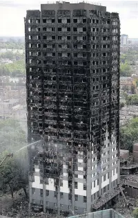  ??  ?? > A hose continues to dampen down Grenfell Tower yesterday