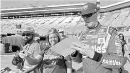  ?? WADE PAYNE/ASSOCIATED PRESS ?? Kyle Busch, who won last week in Texas, signs autographs after qualifying in Bristol on Friday. He edged out his brother, Kurt Busch, by 0.002 seconds to take the pole for Sunday’s race.