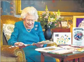  ?? ?? Queen Elizabeth II looks at a display of memorabili­a from her Golden and Platinum Jubilees in the Oak Room at Windsor Castle, Windsor, England.