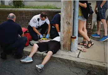  ?? (BRIAN SNYDER/REUTERS) ?? Des secouriste­s tentent de réanimer une victime d’overdose dans une rue de Boston.