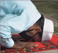  ??  ?? Bashana Ali bows his head in prayer at Stamford Islamic Center on Wednesday.
