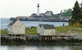 ?? ROBERT F. BUKATY/AP ?? A jogger passes Fisherman’s Point in South Portland, Maine, on June 8. Portland Head Light can by seen in the background.