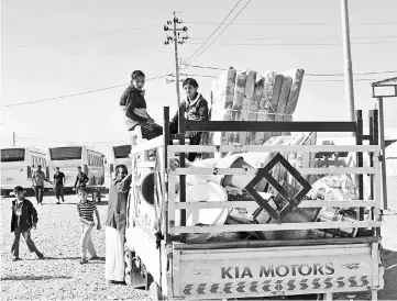  ??  ?? Iraqis displaced due to fighting between federal forces and Kurdish peshmerga fighters leave a camp for internally displaced people (IDP) in Daquq as they head back to Kirkuk. — AFP photo