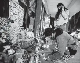  ?? Jeenah Moon / New York Times ?? Mourners leave candles outside Young’s Asian Massage in Acworth, Ga., one of three businesses where eight people were killed by a shooter on Tuesday.