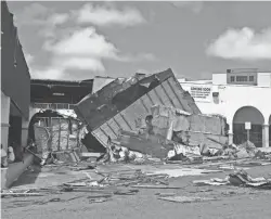  ?? VIRGIN ISLANDS DAILY NEWS ?? Residents seek shade near what was the laundromat at the severely damaged Four Winds Plaza on St. Thomas.