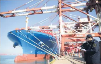  ?? ZHANG JINGANG / FOR CHINA DAILY ?? A container ship waits for departure at Qingdao Port. China’s economic growth is still outpacing that of the rest of the world, according to internatio­nal banks.