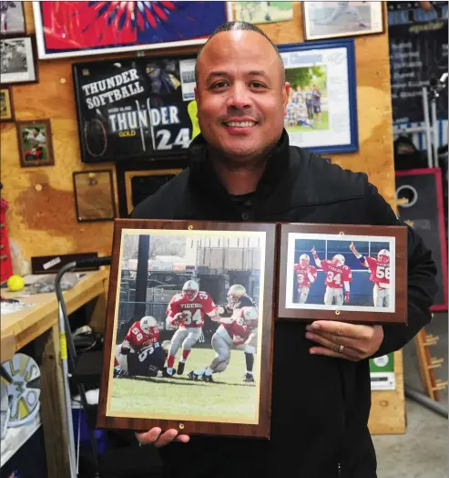  ?? Photo by Ernest A. Brown ?? Former Tolman running back Joey Wilson shows off pictures of the last time the Tigers defeated St. Raphael on the football field, 28-6, on Thanksgivi­ng Day 25 years ago. In that game, Wilson rushed for 205 yards on 19 carries to go along with three touchdowns.