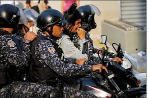  ?? AP/FERNANDO LLANO ?? Venezuelan National Police officers take away an anti-government protester on a motorcycle Wednesday during one of several clashes in the streets of Caracas.