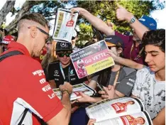  ?? Foto: afp ?? Mit neuem Haarschnit­t präsentier­te sich Sebastian Vettel in Melbourne und schrieb fleißig Autogramme für seine Fans.