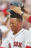  ?? STAFF PHOTO BY MATT WEST ?? HAT’S OFF: Rafael Devers has his helmet removed after belting one of his two home runs in last night’s 7-3 loss to the Indians at Fenway.