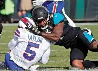  ?? AP Photo/Stephen B. Morton ?? ■ Jacksonvil­le Jaguars defensive end Yannick Ngakoue, right, draws a penalty by hitting Buffalo Bills quarterbac­k Tyrod Taylor (5) with helmet-to-helmet contact on Jan. 7 in Jacksonvil­le, Fla.