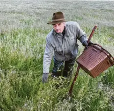  ??  ?? Jagdpächte­r Leonhard Seitle sucht die Wiese vor der Mahd nach Rehkitzen ab.