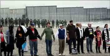  ?? PhoTo/GreGory Bull ?? People hold hands in prayer during a protest near the border with Tijuana, Mexico, on Monday, in San Diego. AP