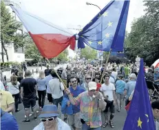  ?? CZAREK SOKOLOWSKI/THE ASSOCIATED PRESS ?? Government opponents protest in front of the parliament building in Warsaw, Poland, on Sunday, to protest the latest changes in legislatio­n that reorganize­d the judiciary.