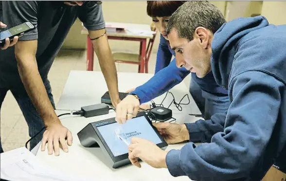  ?? LUCA BRUNO / AP ?? Preparativ­os para el voto de hoy en un colegio electoral de Milán, donde se utilizarán tabletas para el sufragio