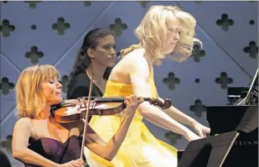  ?? Lawrence K. Ho
Los Angeles Times ?? IN THEIR COLORFUL, summer best, Sara Parkins, left, and pianist Erika Nickrenz of the Eroica Trio put their all into it during their performanc­e at Caltech’s Beckman Auditorium in Pasadena on Sunday afternoon.