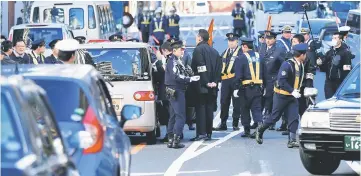  ??  ?? Police officers try to stop a car with a right-wing activist group protesting to call on Russia for the return of a group of islands, called Northern Territorie­s by Tokyo and Southern Kuriles by Moscow, ahead of the arrival of Putin, near the Russian...