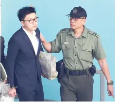  ?? — Reuters photo ?? Leung is held by a correction­al services department officer inside a detention centre before leaving for the High Court for a sentencing hearing.