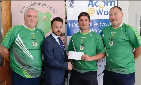  ??  ?? Former O Raghallaig­h’s player Keith Hughes, who has recently taken up a Financial Adviser role with Acorn Life, presents a sponsorshi­p cheque to Under 14 team manager Cathal McGinty towards the club’s Feile Peile na nOg celebratio­ns. Also pictured are team mentors Aidan Lambe and Alan Smith.