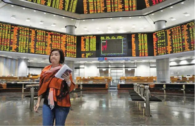  ?? Reuters ?? ↑ A broker exits the Malaysian Stock Exchange in Kuala Lumpur on Monday.