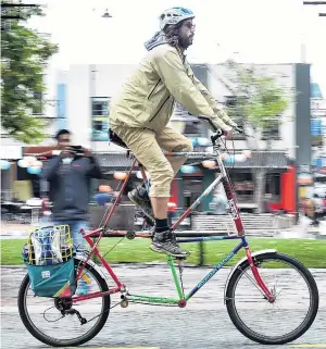  ?? PHOTO PETER MCINTOSH ?? Lofty ambition . . . Kyle Sanders, of the United States, rides his custombuil­t double bike through the Octagon earlier this week. Mr Sanders, who is on holiday, built the bike at the Crooked Spoke workshop in Dunedin and plans to travel through...