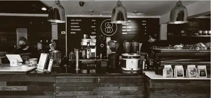  ?? Photos by Yi-Chin Lee / Staff photograph­er ?? Throughgoo­d Coffee baristas Abbey Barth and Jonny Reeves work behind the counter after reopening May 28 in Houston. Customer traffic is about half of pre-pandemic levels.