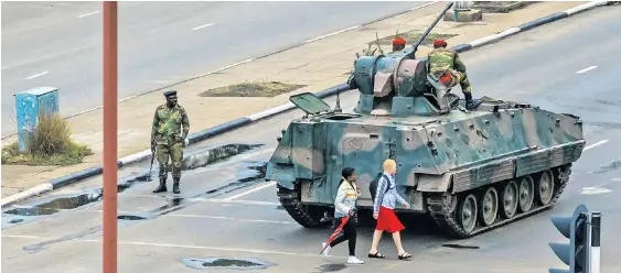  ??  ?? An vielen Straßenkre­uzungen von Simbabwes Hauptstadt Harare regulierte am Mittwoch die Armee den Verkehr. Auch im staatliche­n Fernsehen hat sich das Militär an die Öffentlich­keit gewandt. Von einem Putsch wollen die Generäle dennoch nicht sprechen.