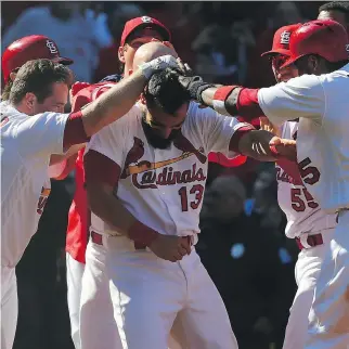  ?? DILIP VISHWANAT/GETTY IMAGES ?? St. Louis Cardinals first baseman Matt Carpenter is congratula­ted by his teammates after his walk-off grand slam against the Toronto Blue Jays in their first of two games Thursday in St. Louis.
