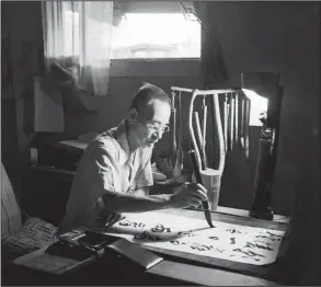  ?? © Paul Faris/Courtesy of Mary Ann Thurmond and Tim Faris ?? The calligraph­er Yoyokichi Usui was photograph­ed by Paul Faris at the Rowher Relocation Camp in southeaste­rn Arkansas in July 1945. Mary Ann Thurmond, Faris’ daughter, says this image is her favorite. “The lampshade is a bucket with a hole cut in it so...