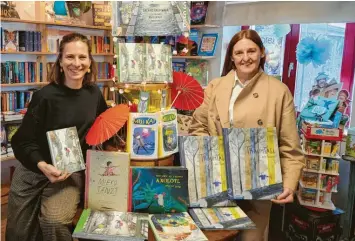  ?? Foto: Uschi Nagl ?? Am Büchertisc­h in der Buchhandlu­ng Colibri kann man sich alle Bücher des Limbion-Verlags aus Dießen anschauen. Buchhändle­rin Ulrike Kreutzer (links) und Verlegerin Lisa Hammerl (rechts) freuen sich auf viele große und kleine LeserInnen.