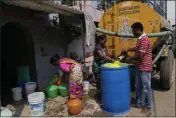  ?? AIJAZ RAHI — THE ASSOCIATED PRESS ?? Residents of Ambedkar Nagar, a low-income settlement in the shadows of global software companies in Whitefield neighborho­od, collect potable water from a private tanker in Bengaluru, India, Monday.