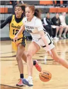  ?? SARAH PHIPPS/THE OKLAHOMAN ?? Norman North's Olivia Watkins drives to the basket as Sand Springs' Tay'Ja Butler defends during a Putnam City Invitation­al game at Putnam City High School in Oklahoma City on Thursday night.