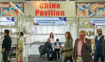  ?? ZHANG FAN / XINHUA ?? A representa­tive of a Chinese bedding company talks with a trader at the Heimtextil 2024 in Frankfurt, Germany on Jan 9.