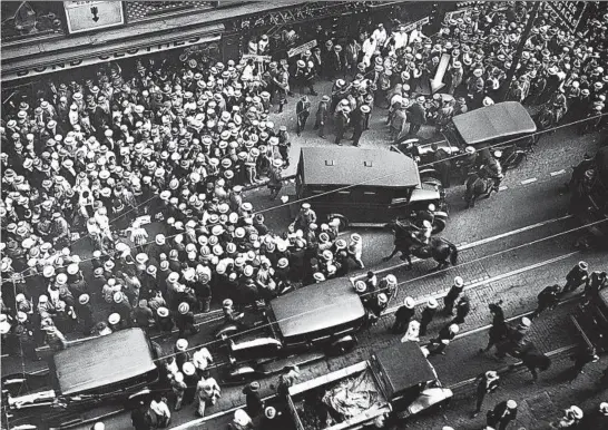  ?? CHICAGO TRIBUNE HISTORICAL PHOTO ?? The scene on Madison Street near Dearborn Street, where Tony Lombardo was fatally shot on Sept 7, 1928. An arrow points to the body on the sidewalk.