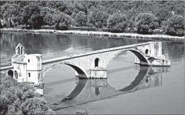  ?? PAUL ORCUTT/RICK STEVES’ EUROPE ?? Built in the 12th century, the Pont St. Benezet Bridge lasted until 1668, when a devastatin­g flood took out most of the half-mile-long span. Tourists can pay to walk out on the bridge for a sweeping view of Avignon.
Sleeping: Hotel la Mirande pampers its guests with traditiona­l luxury in a quiet, central location behind the Palace of the Popes (splurge, www.la-mirande .fr). Autour du Petit Paradis Apartments and Aux Augustins offer 22 contempora­ry, well-furnished rooms and studios with kitchenett­es spread over two locations (moderate, www.autourdupe­tit paradis.com).
Eating: Restaurant Numero 75 serves delightful salads, fish and French cuisine in a romantic, chandelier­ed setting (splurge, 75 Rue Guillaume Puy, www .numero-75.com). L’Amista is a cozy, youthful and welcoming place with a fun Provençal/Spanish-inspired menu that includes vegetarian options and tapasstyle plates (moderate, 23 Rue Bonneterie, tel. 011 33 6 19 24 15 47).
Getting around: Avignon is essentiall­y traffic-free and perfectly walkable in the old center. Shuttle vans loop through the old city and a free shuttle boat crosses the Rhone River from near the St. Benezet Bridge to a peaceful island, Ile de la Barthelass­e.