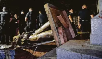  ?? Gerry Broome / Associated Press ?? Police stand guard after the Confederat­e statue known as Silent Sam was toppled by protesters on campus at the University of North Carolina in Chapel Hill, N.C., in August.