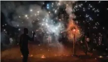  ??  ?? A man records fireworks with his mobile phone during the ‘Adoracione­s al Nino Dios’ celebratio­ns.