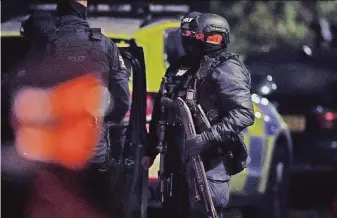  ?? Peter Byrne / Press Associatio­n ?? Police officers gather outside a property that was searched in Sefton Park district of Liverpool. The probe followed an explosion outside a hospital that killed the suspected bombmaker.