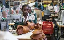  ??  ?? An employee of the Courteney boot company works on the production line.