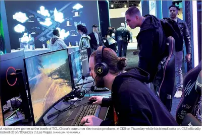  ?? CHANG JUN / CHINA DAILY ?? A visitor plays games at the booth of TCL, China’s consumer electronic­s producer, at CES on Thursday while his friend looks on. CES officially kicked off on Thursday in Las Vegas.