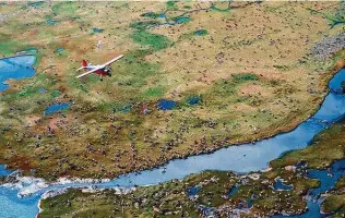  ?? Associated Press file photo ?? In this photo from the U.S. Fish and Wildlife Service, an airplane flies over caribou from the Porcupine herd on the coastal plain of the Arctic National Wildlife Refuge.