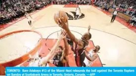  ??  ?? TORONTO: Bam Adebayo #13 of the Miami Heat rebounds the ball against the Toronto Raptors on Sunday at Scotiabank Arena in Toronto, Ontario, Canada. —AFP